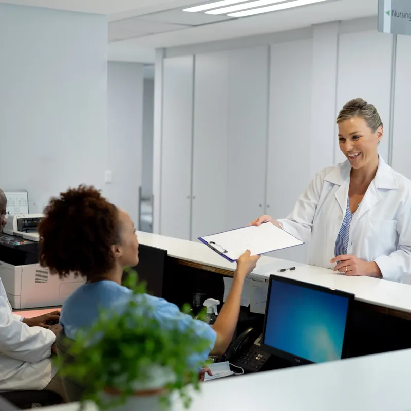 A doctor passing a document to a patient